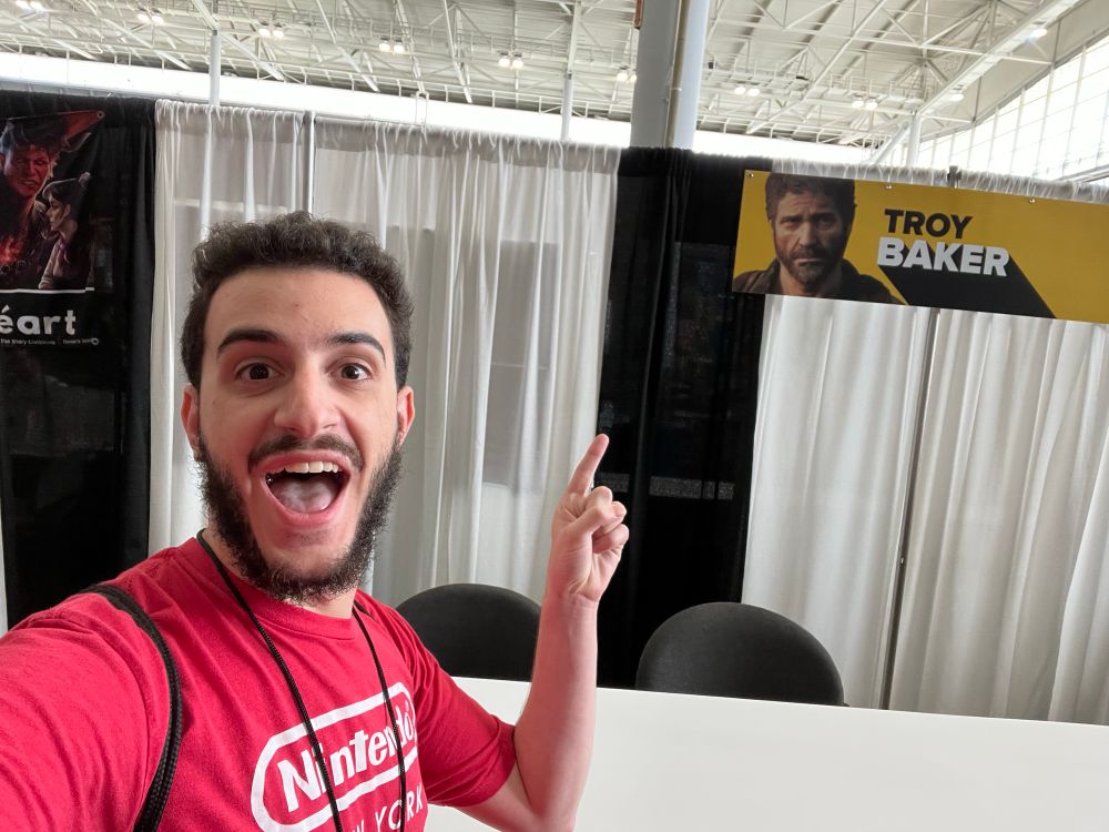 Me standing in front of the autograph table for Troy Baker. The table is empty, as the joke was the fact he wasn't there.