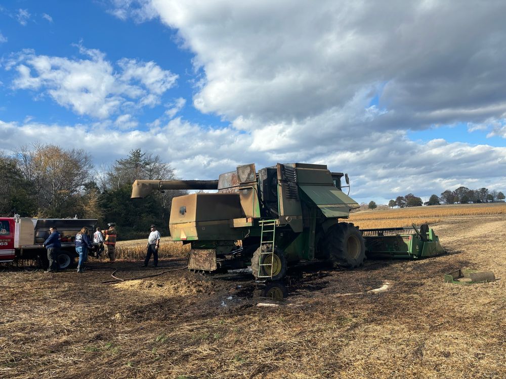 John Deere 9500 Combine after a fire on the back end, volunteer firefighters and a truck in the background. 