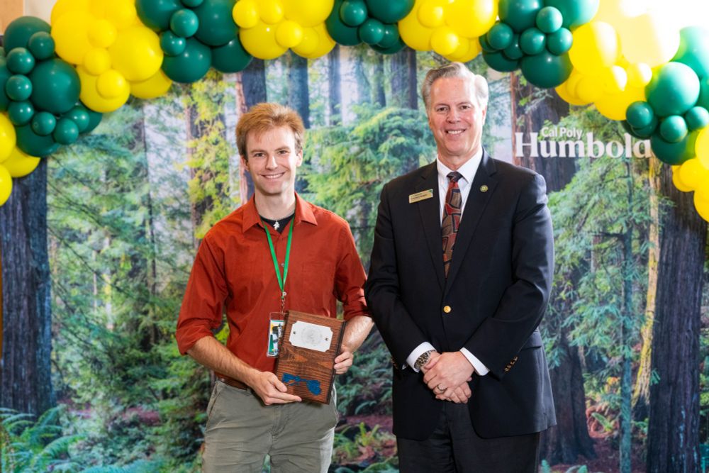 David Schmitz poses for a photo with President Spagna with their award plaque.