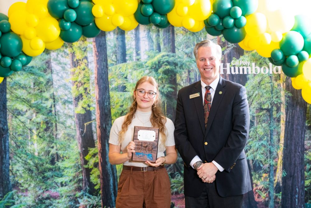 Harmony Switzer-Tryon poses with President Spagna and an award plaque.