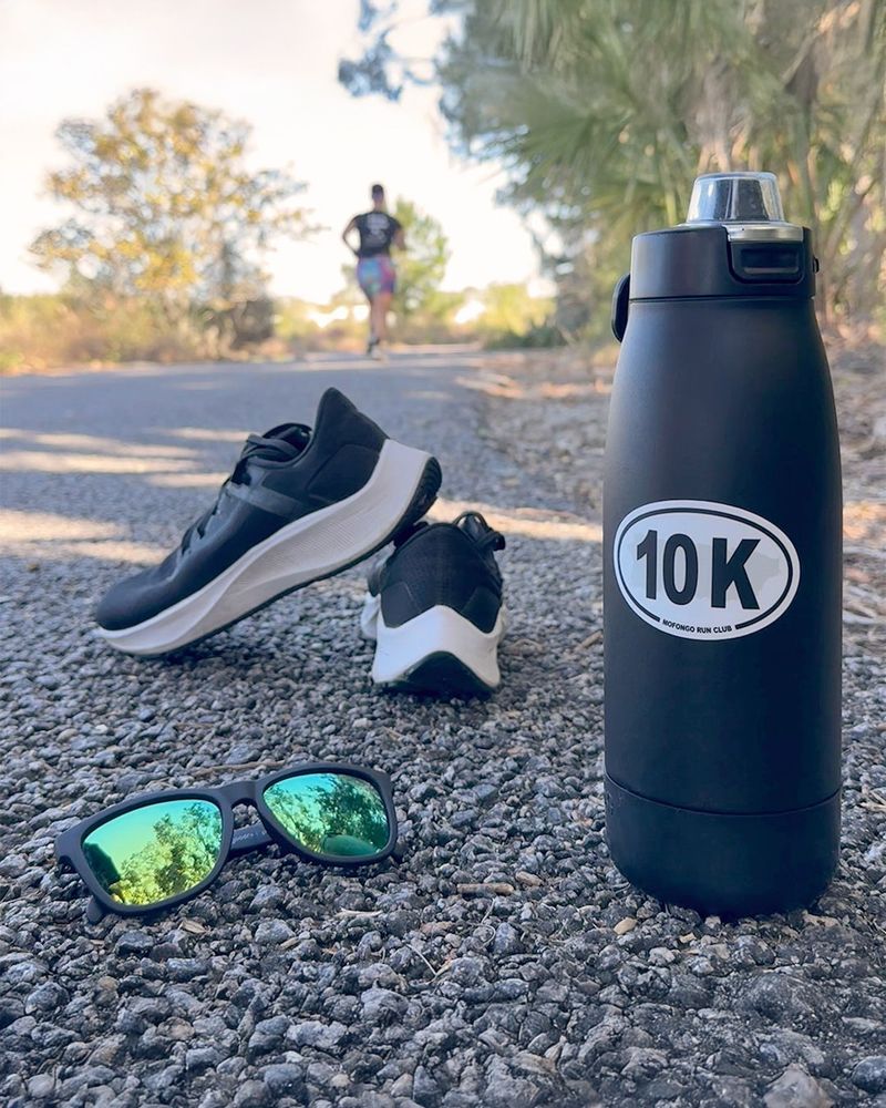 Foto de una calcomanía (sticker) ovalada, en una botella de agua, con la distancia 10K y la silueta de la isla de Puerto Rico.