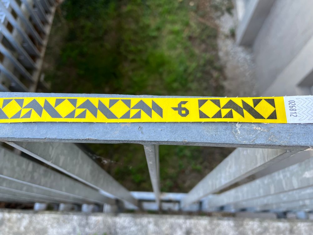 Ein Tagespassbändchen zur Gulaschprogrammiernacht 23 / 2025 liegt auf einem Geländer