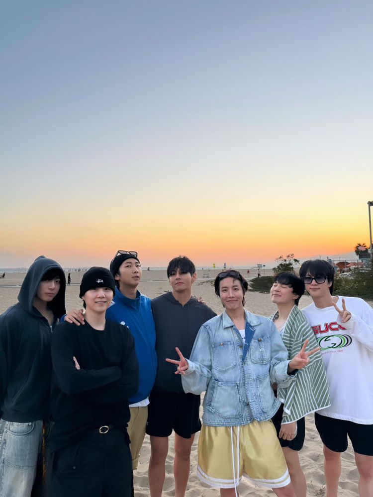 bts ot7 picture at the beach with a sunset in the background
