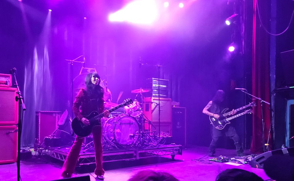 The three members of Boris on stage, bathed in pink light.
