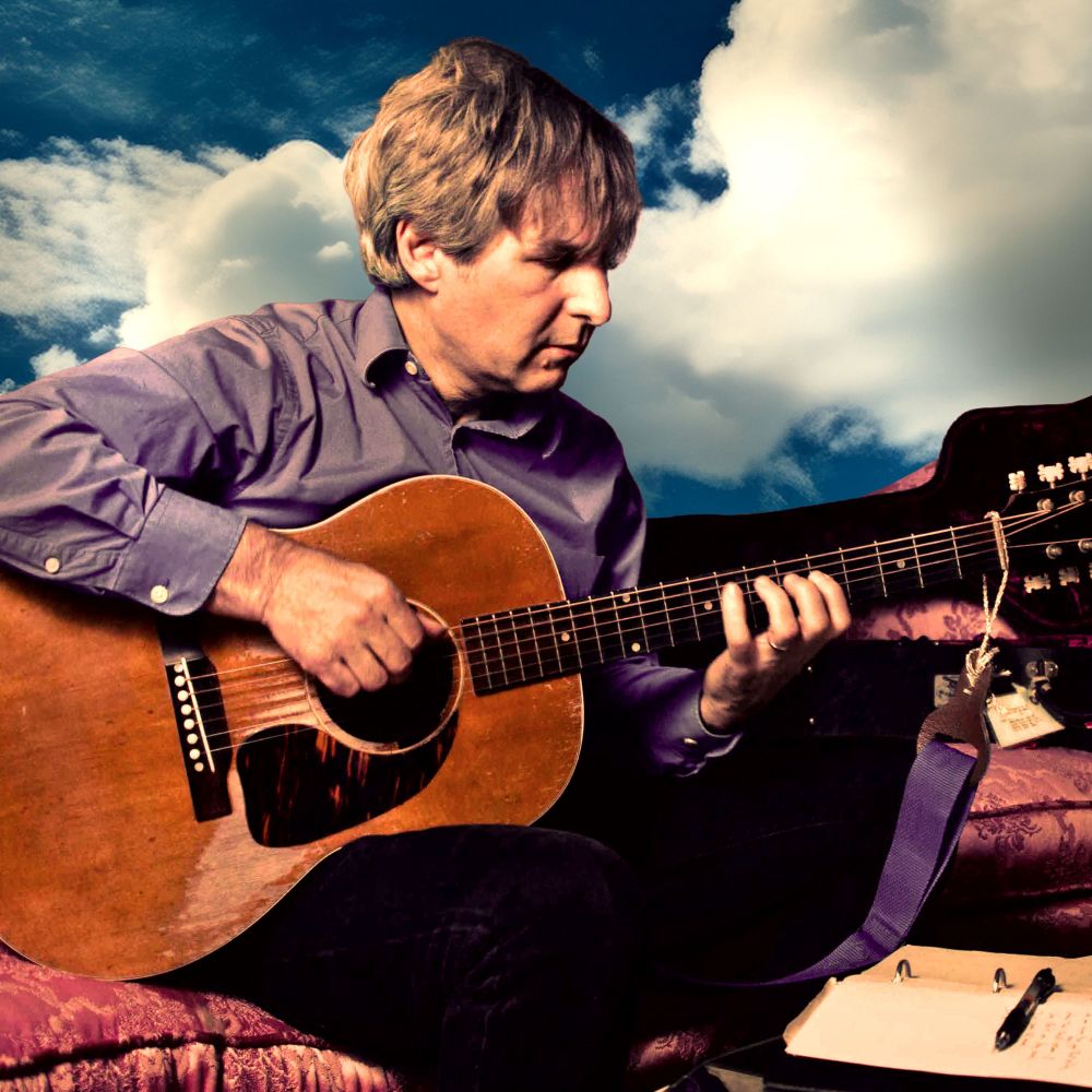Publicity still of Chris Stamey playing an acoustic guitar