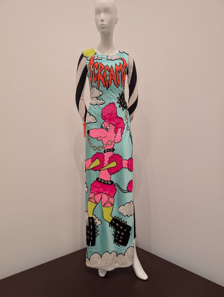 A dress in the Cat and Dog exhibition which has a beaded half-poodle half-human dog on the front