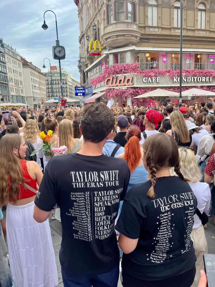 eine große anzahl junger menschen steht auf einem platz. alle singen. 