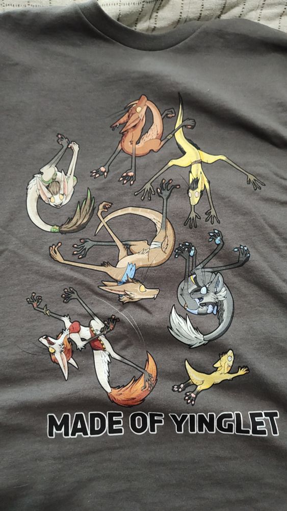 A gray shirt with a bunch of tumbling yinglets of various colors and the text "Made of Yinglet" at the bottom