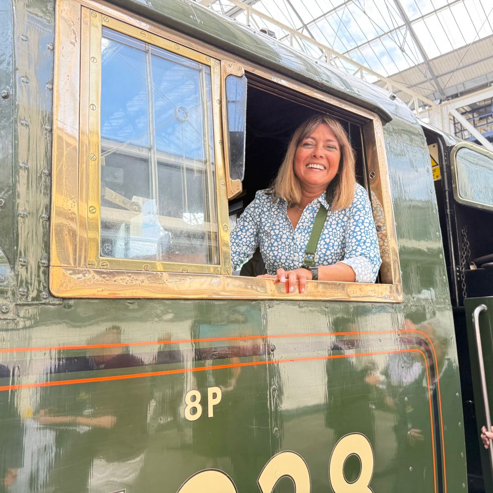 Woman sitting in locomotive train drivers car