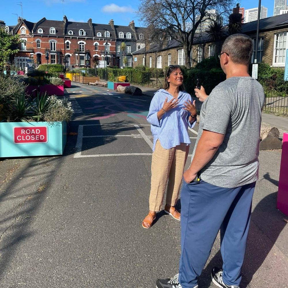 Two people standing and talking in a street in south London. 