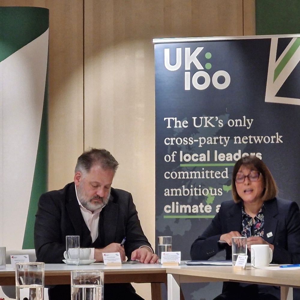 Two people sitting as part of a round table discussion