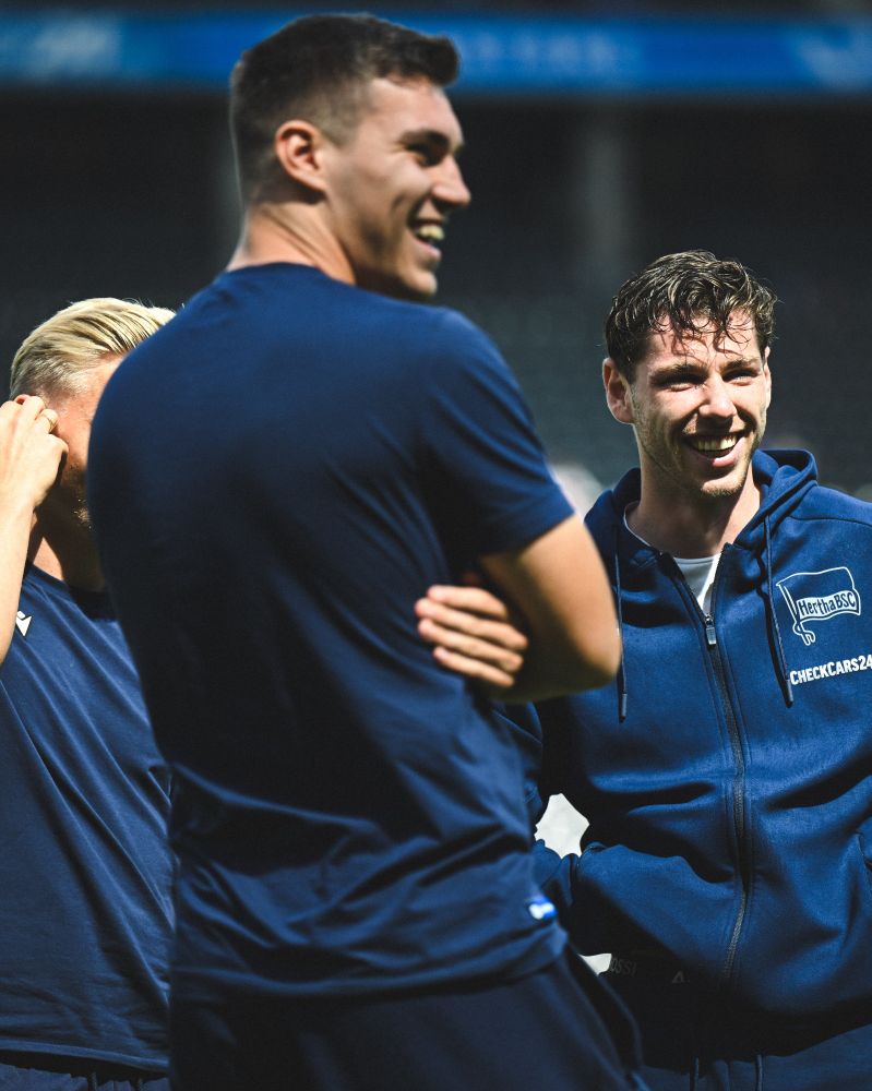 Andi Müller und Marcel Beifus lachen mit Herthas Leon Jensen.