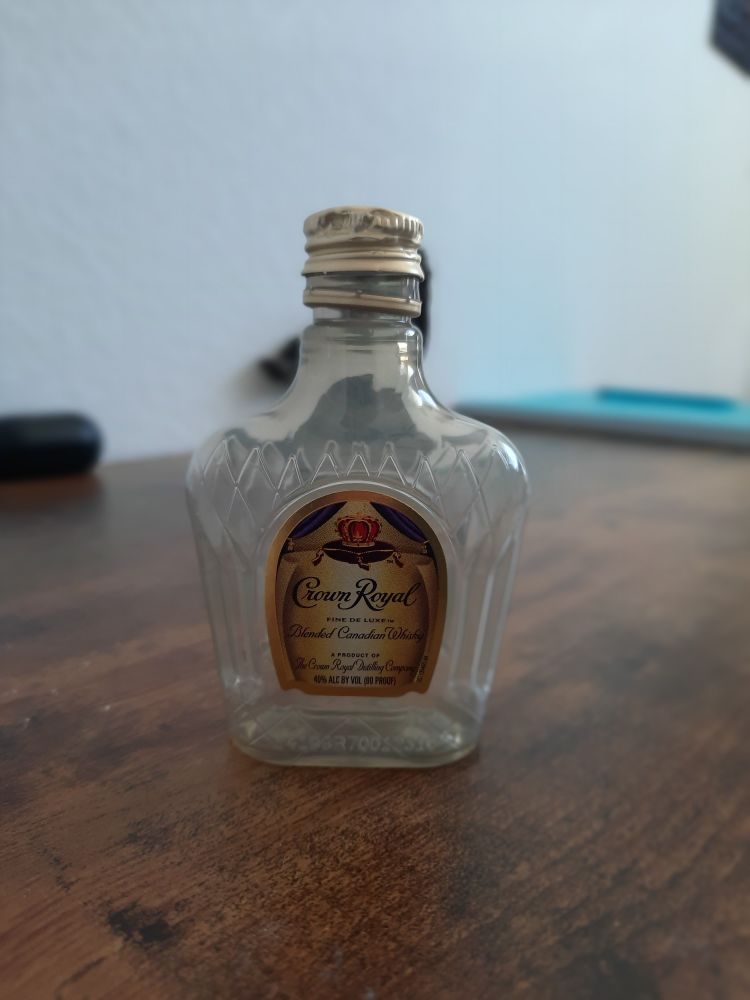 beautiful portrait of an empty Crown Royal shooter on a fake wood desk