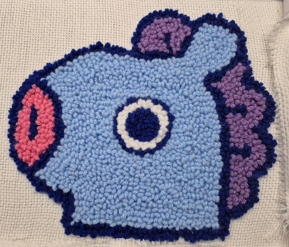 A needlepunch image of a blue cartoon horse head.