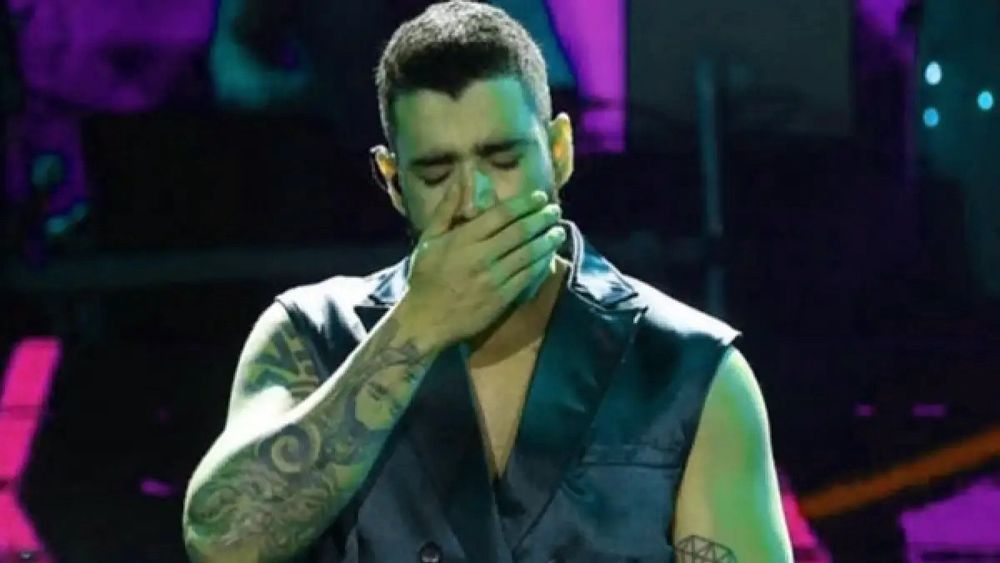 Gusttavo Lima com os olhos fechados e a mão na boca