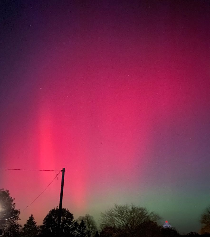 Shot of the night sky with streaks of pink and green
