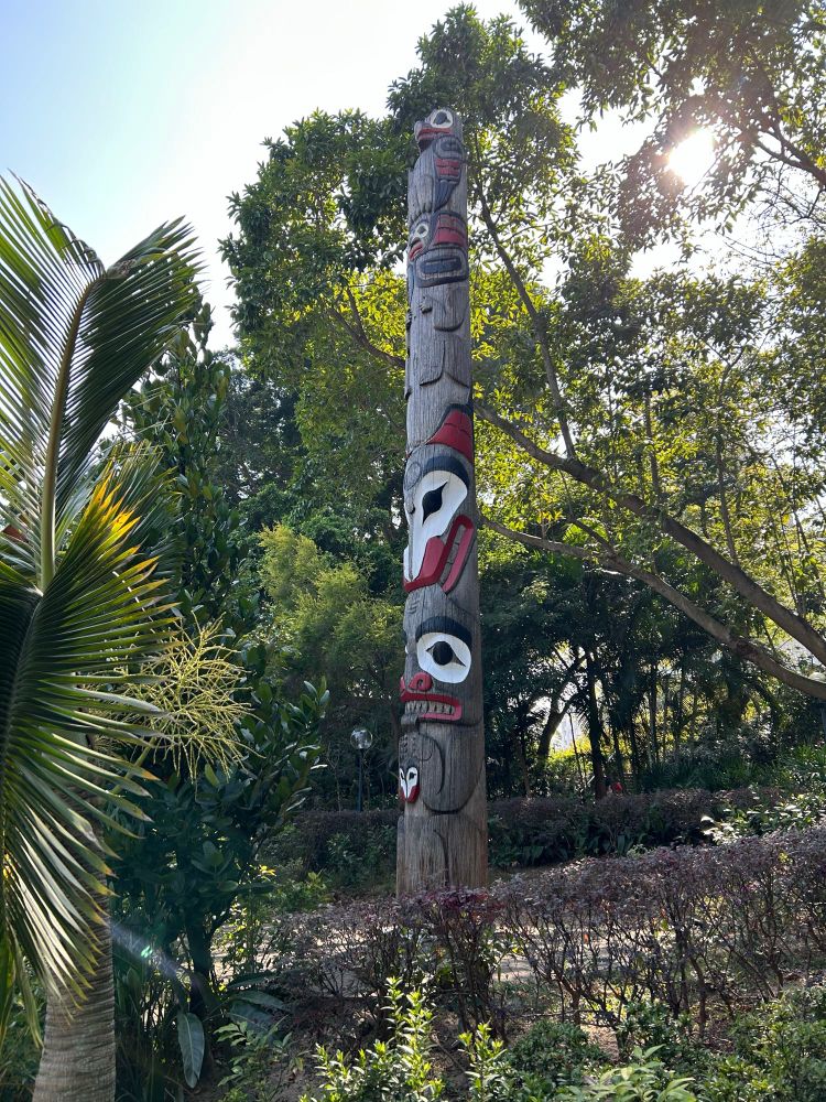 A totem pole amongst the sub-tropical vegetation of Kowloon Park, Hong Kong. It was probably made by a member of the Kwakwa̱ka̱ʼwakw Nation of northern Vancouver Island, Canada, in the 1970s. 