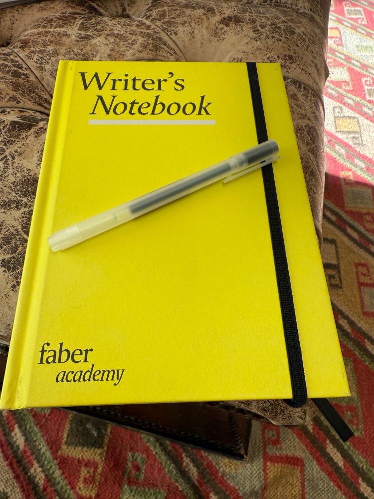 Photo of yellow Writer’s Notebook from the Faber Academy with pen