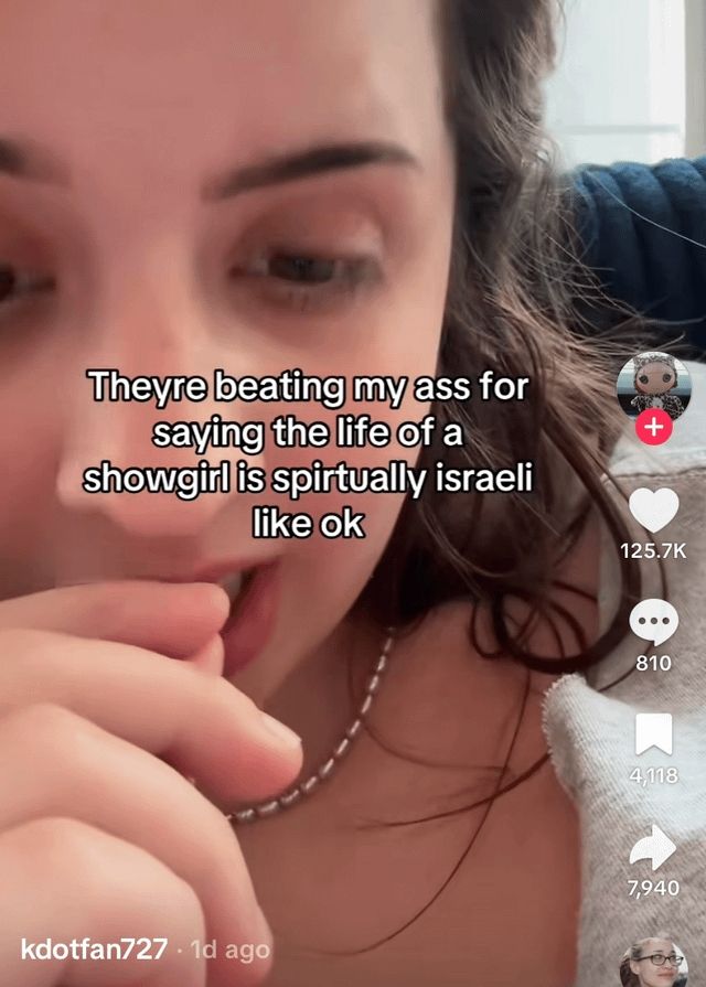 White woman with long brown hair holding her hand infront of her mouth. 
Video text says
" theyre beating my ass for saying the life of a showgirl is spirtually isreali like ok"