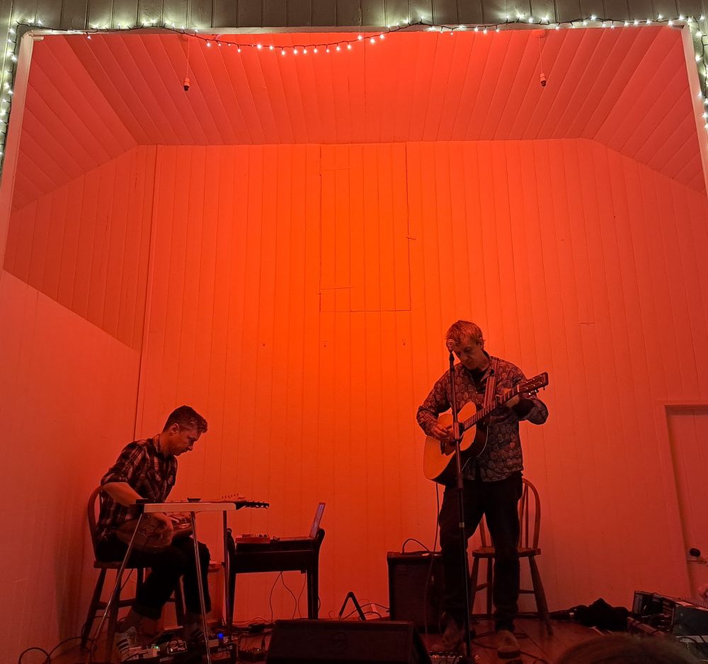 Steve Gunn standing and James Elkington seated, both playing guitar