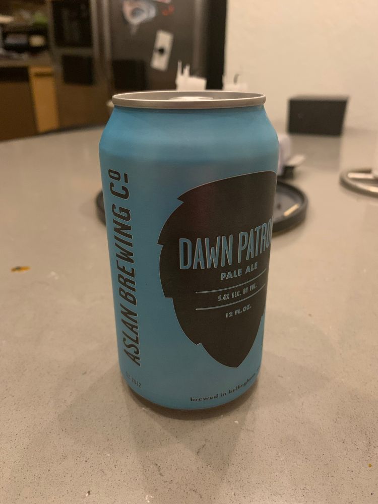 A can of Aslan Brewing’s Dawn Patrol ale in front of Shabbat candles and a kiddush cup. 