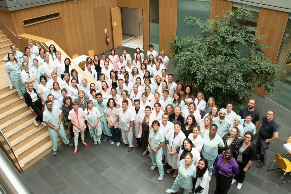 Photo de groupe du personnel du pole de gynéco dans le hall du bâtiment
