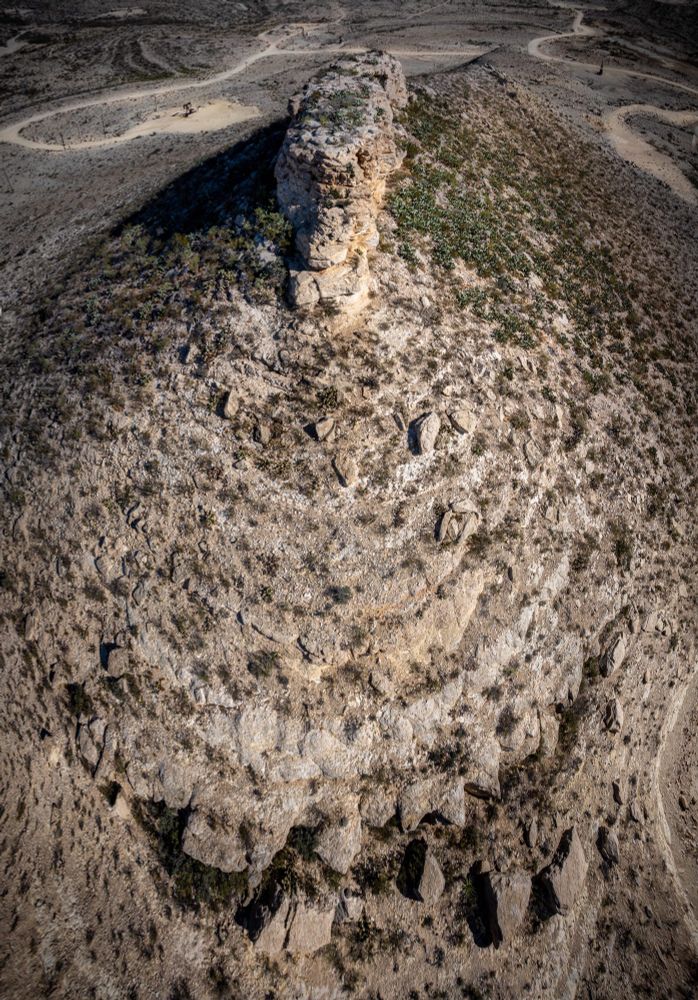 Aerial panorama of Tunas Peak in Pecos County, TX seen at mid-day from a drone at 375 feet. There are several roads at the base of the peak, leading to oil pumps. 