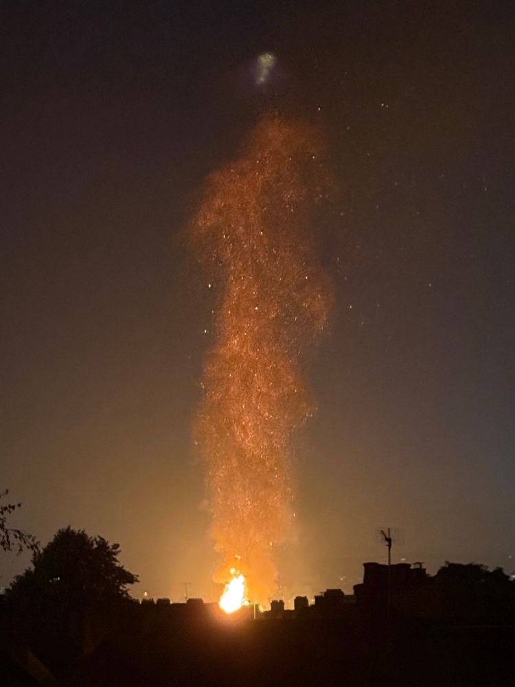 A plume of embers above a bonfire taken from a distance but brighter 