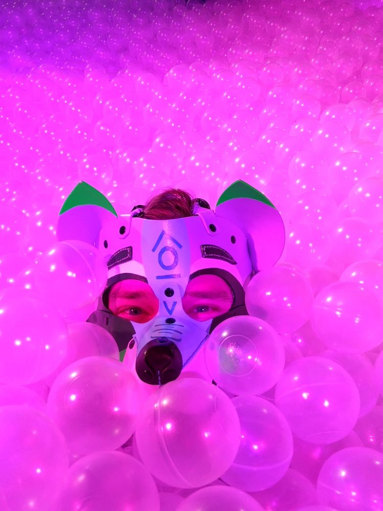 A pic of myself body deep in a swimming pool sized ball pit of clear plastic balls. 