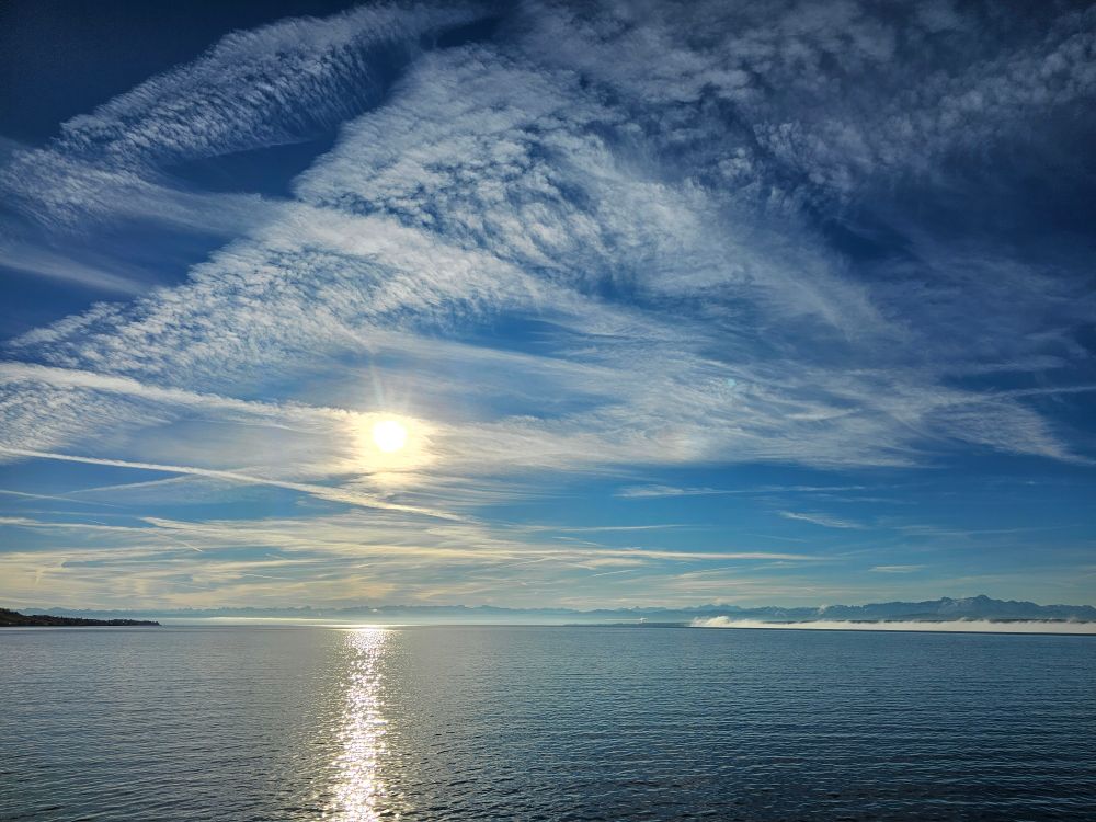 Cirruswolken und Kondensstreifen über dem Bodensee. 