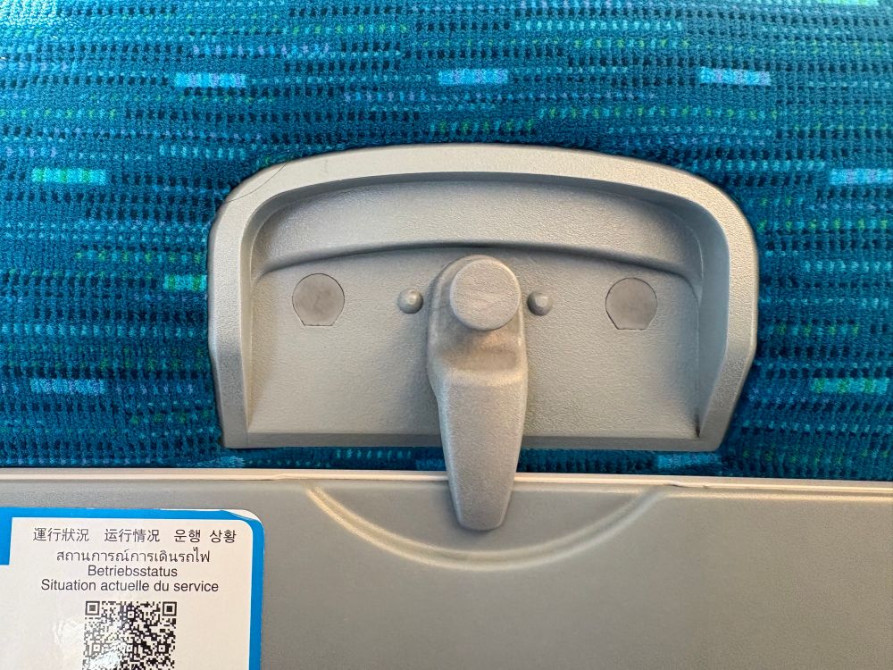 A seat tray table latch that looks like a smiley face 