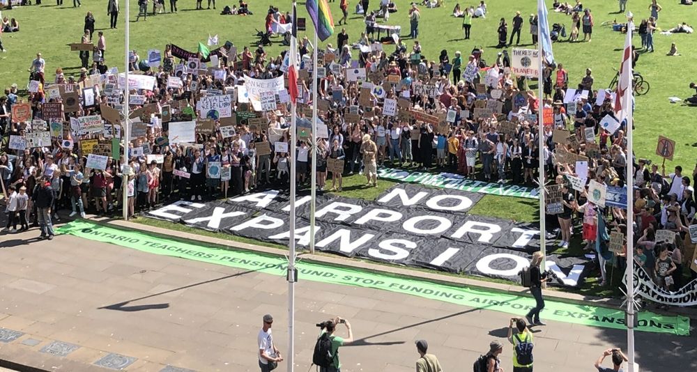 No airport expansion sign surrounded by people on College Green Bristol