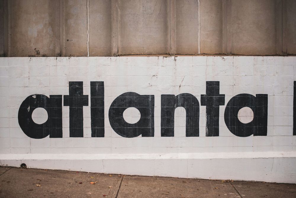 White brick wall with the word atlanta painted in black.
