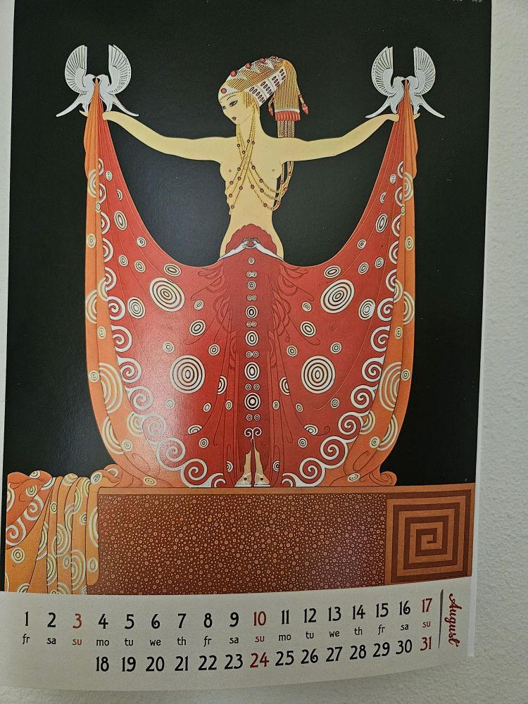 Well I'll do my best here, but... It's a bare chested woman with what I assume is hair styled after ancient Egypt (which by the way also loops under her arms and crosses her chest to attach to her earrings). With outstretched arms she holds open a blood red dress that is helped in being held aloft by four stylised white, birds. The dress appears to open from her innards, though she seems unconcerned about it. It is decorated with white concentric circles and trimmed in orange. Honestly, there's a lot more going on here but I've tried to cover the main points.