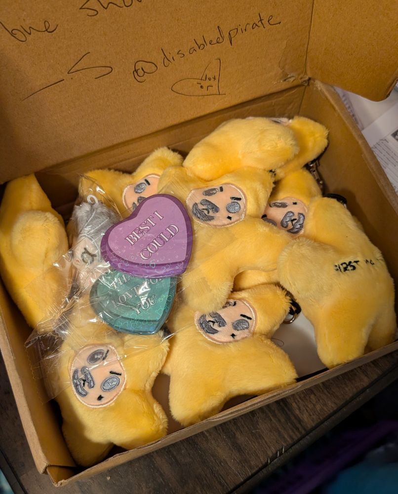 An open box that is full of little yellow plush stars with the face of Izzy Hands. 