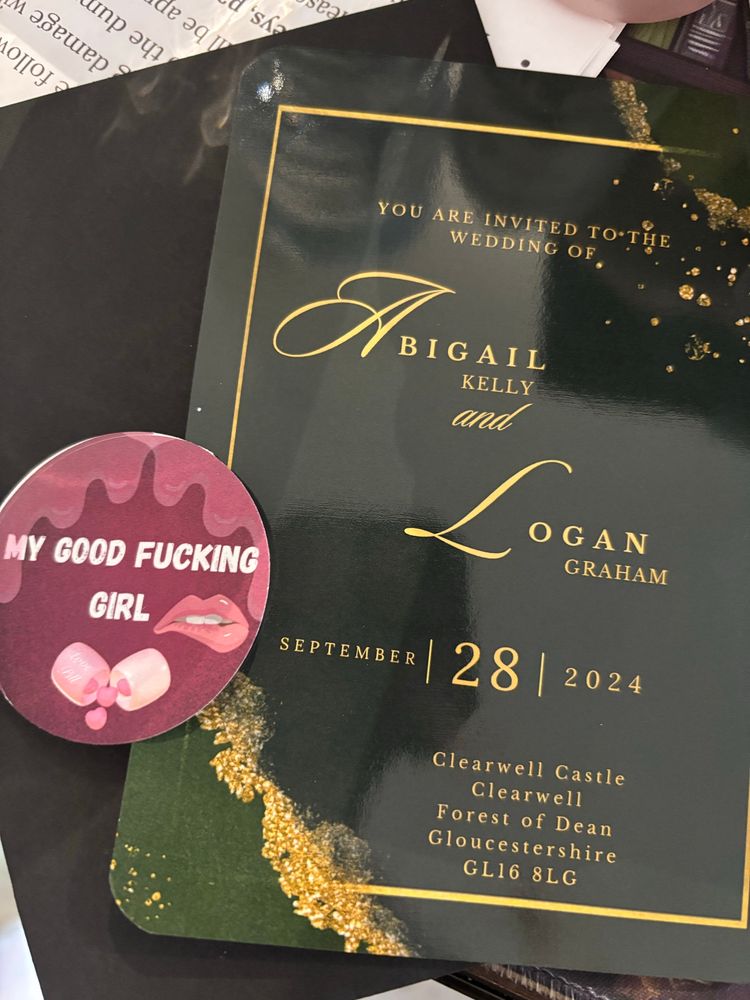 Wedding invitation for the main characters of It Shouldn’t Be You by Shannon Jade and a sticker that says “My Good Fu*king Girl” in reference to a line in the book. 