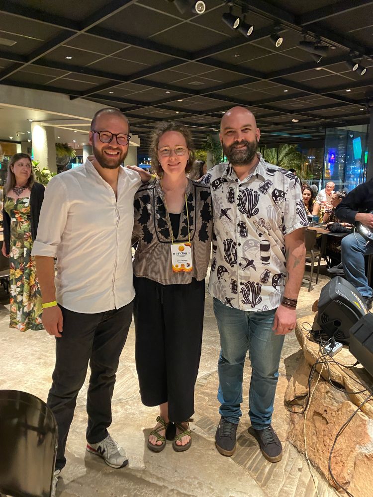 Three friends stand together smiling