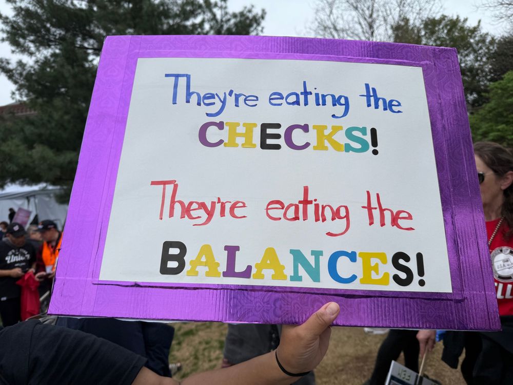 Sign stating, “they’re eating the checks!  They’re eating the balances!”