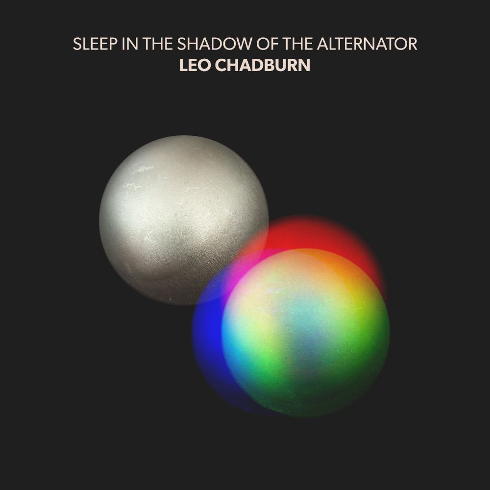 Leo Chadburn, "Sleep in the Shadow of the Alternator" album artwork. Two iron spheres float in a black void. As they touch, one sphere glows red, green and blue.