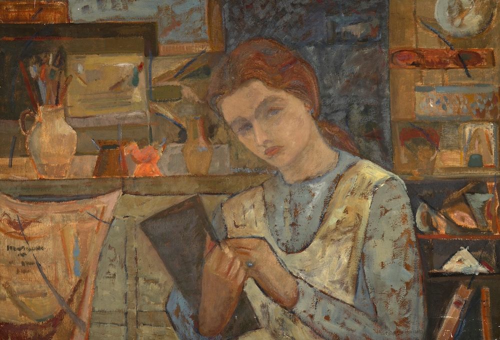 A painting of a woman with pale skin, auburn hair and blue eyes, standing with a sketchpad cradled in her right arm. With her left hand, she appears to be drawing in the sketchbook. Behind her are shelves, cupboards and a counter filled with paintbrushes, vases, and other studio equipment. 