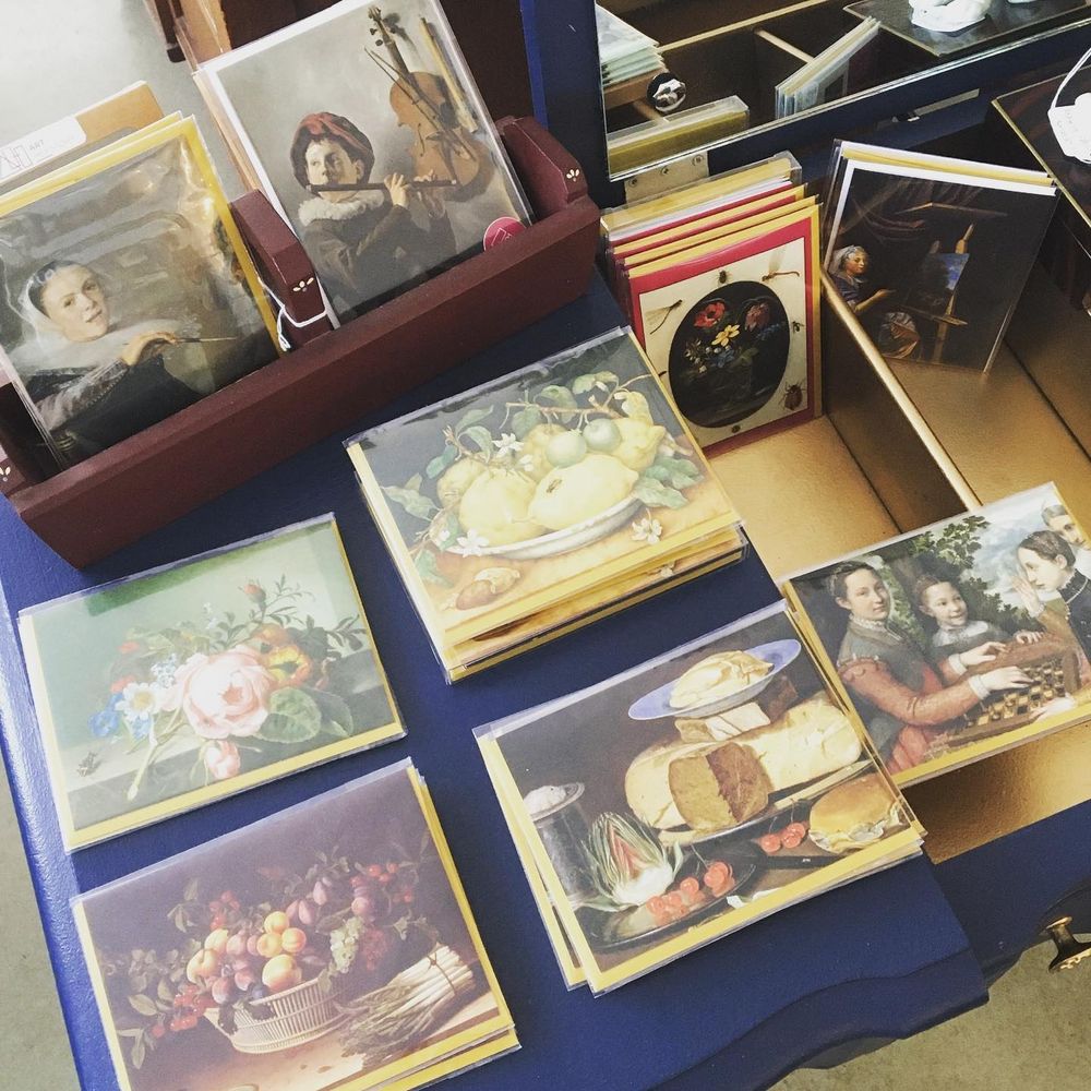 A photo of individual note cards, in plastic sleeves, on display in a gift store. Each card reproduces a painting by a historic woman artist, including the painters named in this post.