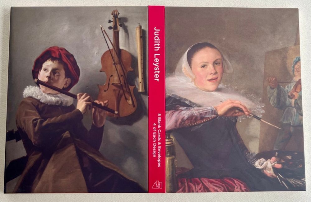 A Judith Leyster note card wallet open showing back cover, spine and front cover. The back cover reproduces the artist's self-portrait from the 1630s. The spine contains the title and product info in white text reversed out of a hot pink background. The back cover reproduces the artist's depiction, also from the 1630s, of a seated boy playing a flute, with a violin and recorder hanging on a wall beside him.