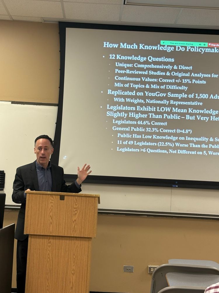 Professor presenting his research, showing a slide about his data 