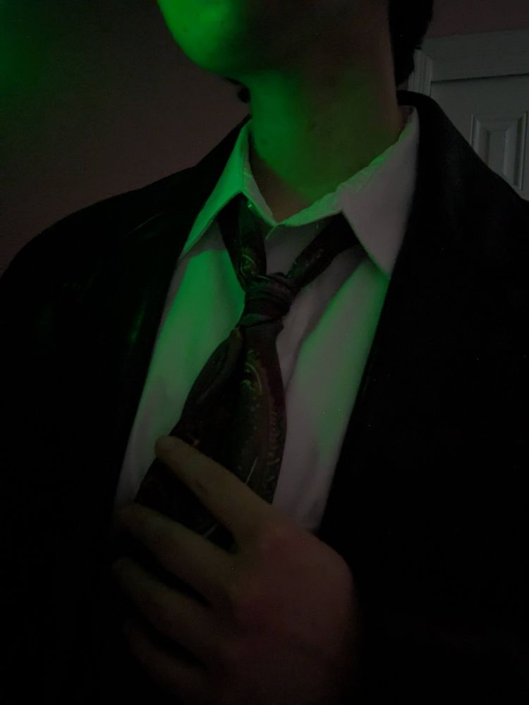 Me in dark place Alex Casey cosplay under green lighting.