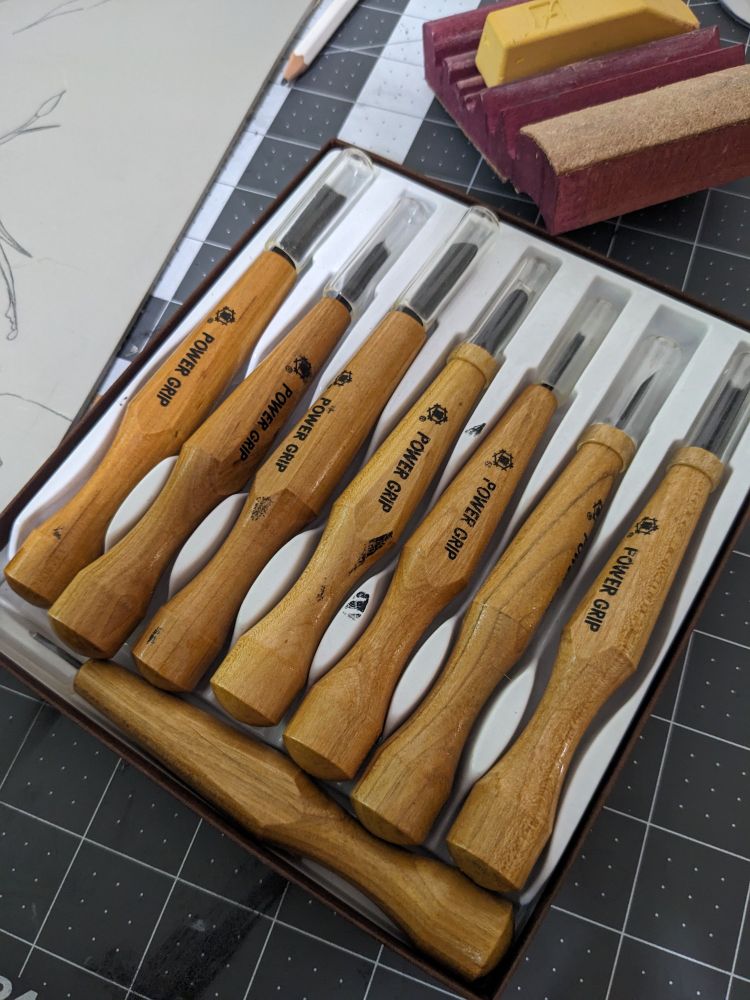 A pack of power grip carving tools in a case sitting on a desk 