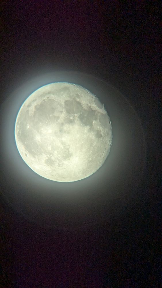 A photo of the moon taken through a 20mm telescope eyepiece