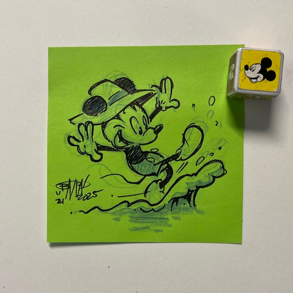 Mickey wearing fisherman’s hat kicks up water from a puddle. 