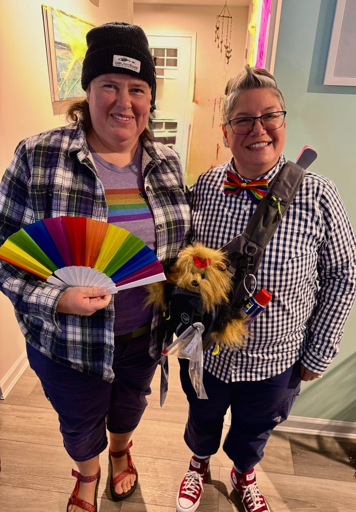 Two women in various rainbow attire. 