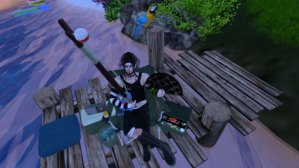 Henry fishing at The Moonstone Studio holding a fishing pole, Derpy, and a hand fan, sitting in a fishing chair on the dock