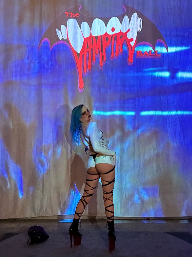JayJayy posing backwars to show off their vampire stripper halloween costume and how it accentuates their butt